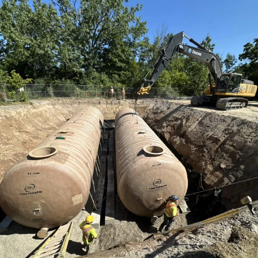 GEDCO Excavating installing 100 cubic metre underground fiberglass tanks with excavator support.